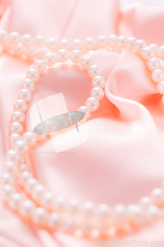 Image of Pearl necklace on pink satin fabric