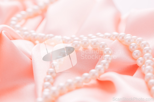 Image of Pearl necklace on pink satin fabric