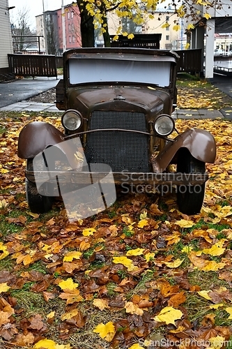 Image of old vintage car in autumn with autumn leaves