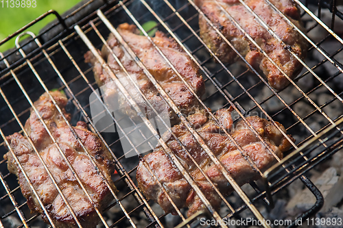 Image of pieces meat char-grilled over flame