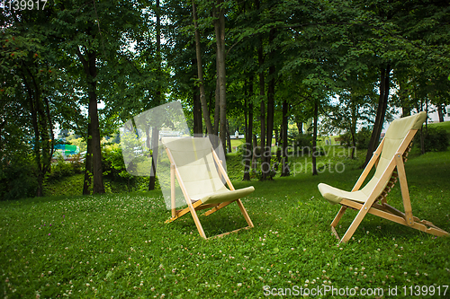 Image of couple of chairs in park at sunset 