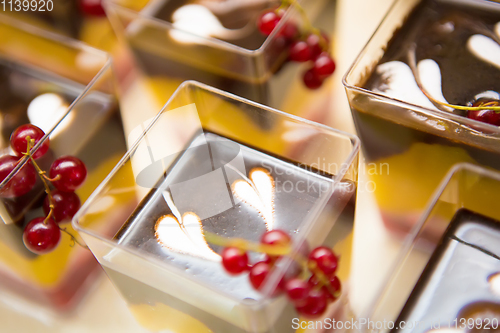 Image of Layered dessert with fruits, nuts and cream cheese in glass jar