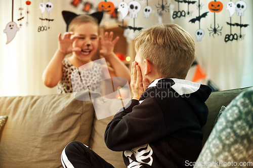 Image of kids in halloween costumes having fun at home