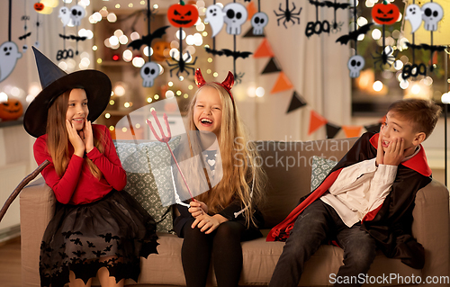 Image of kids in halloween costumes playing at home