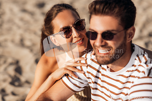 Image of happy couple chilling on summer beach