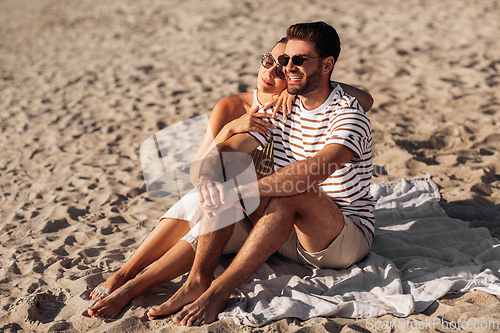 Image of happy couple chilling on summer beach