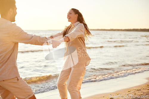 Image of happy couple hugging on summer beach