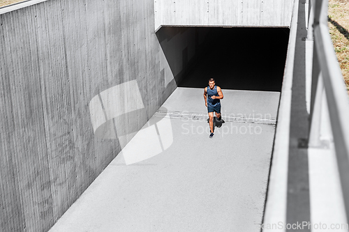 Image of young man running out of tunnel