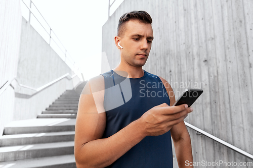 Image of young athlete man with earphones and smartphone