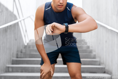 Image of young man with fitness tracker on city street