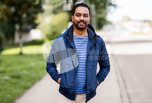 Image of happy smiling indian man in jacket on city street