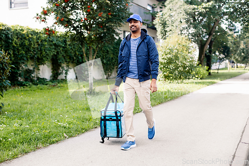 Image of indian delivery man with bag walking in city