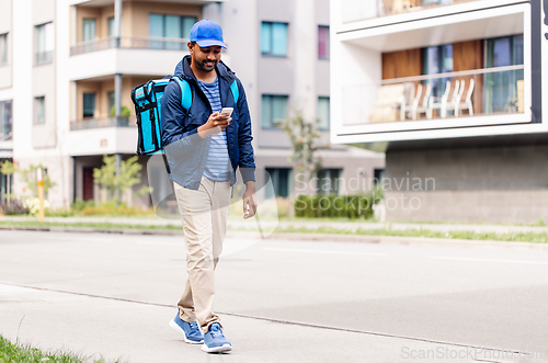 Image of smiling indian delivery man with bag and phone