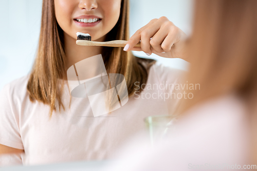 Image of teenage girl with toothbrush brushing teeth