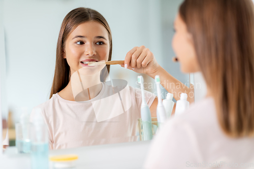 Image of teenage girl with toothbrush brushing teeth