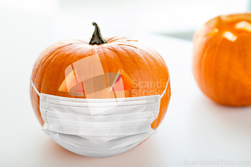 Image of carved pumpkin or jack-o-lantern in medical mask