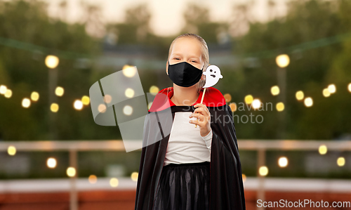 Image of girl in mask and costume of dracula on halloween