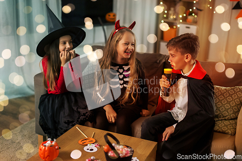 Image of kids in halloween costumes playing at home