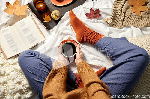 Image of woman drinking coffee at home in autumn