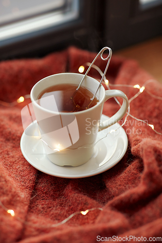 Image of cup of tea and garland lights on window sill