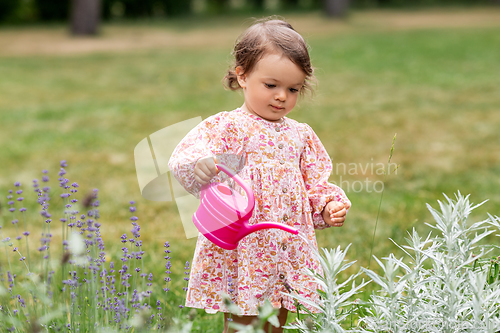 Image of happy baby girl with watering can in summer garden