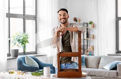 Image of happy man renovating old wooden table at home