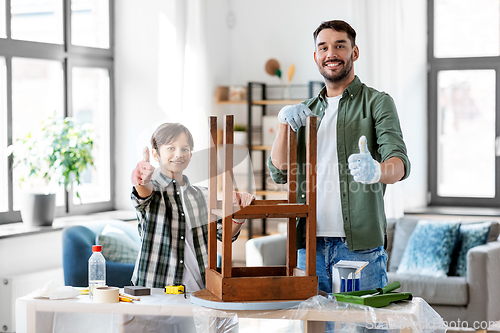 Image of father and son sanding old table with sponge