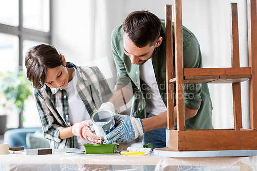 Image of father and son pouring grey color paint into tray