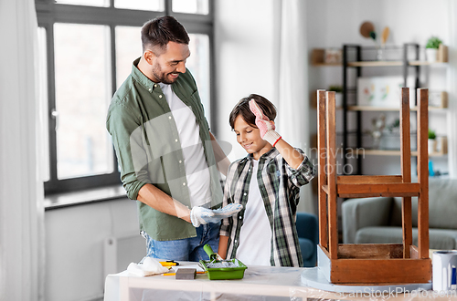 Image of father and son making low five and restore table