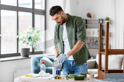 Image of man opening can with grey color at home