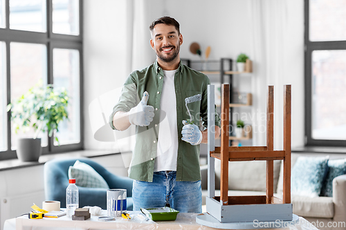 Image of man painting old table in grey color at home