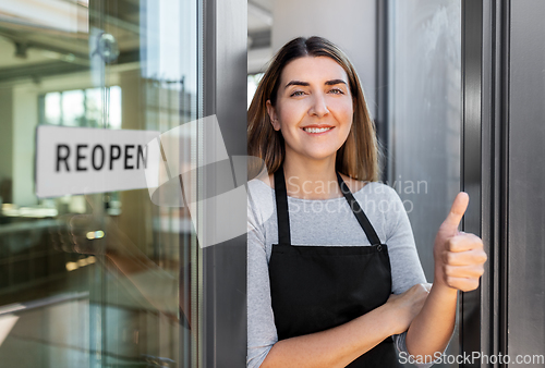 Image of woman with reopen banner on door showing thumbs up