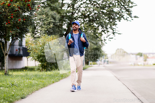 Image of smiling indian delivery man with bag and phone