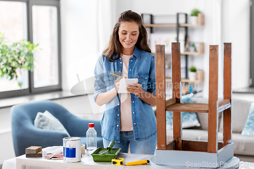 Image of woman with old table writing to notebook at home