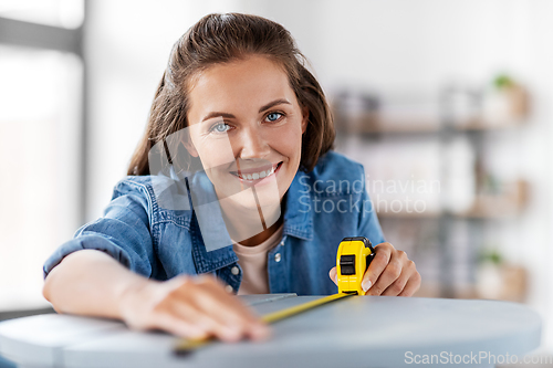 Image of woman with ruler measuring table for renovation