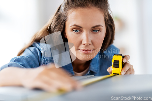 Image of woman with ruler measuring table for renovation