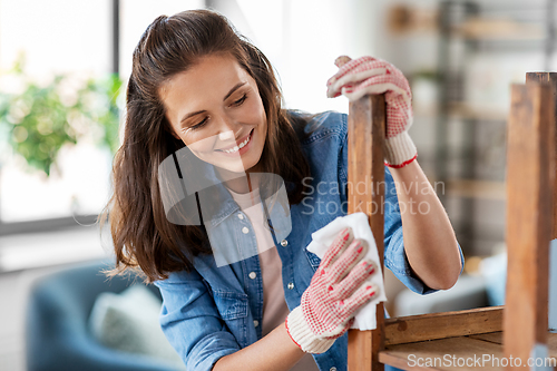 Image of woman cleaning old table surface with tissue