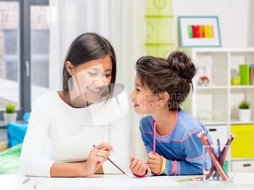 Image of happy mother and daughter drawing at home