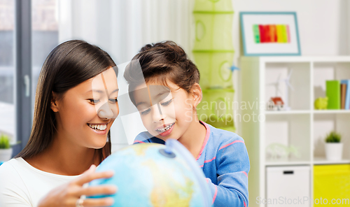 Image of mother and daughter with globe at home