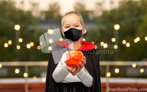 Image of girl in mask and costume of dracula on halloween