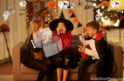 Image of kids in halloween costumes playing at home