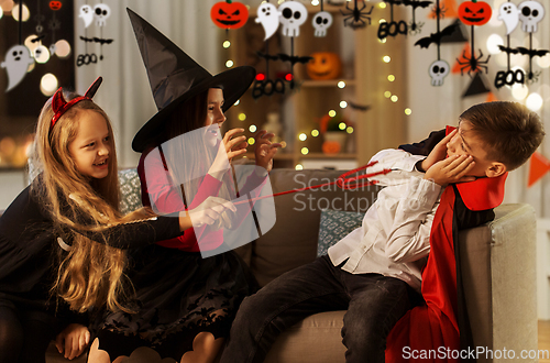 Image of kids in halloween costumes playing at home