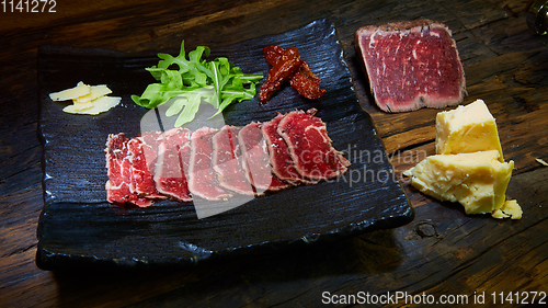 Image of Barbecue wagyu roast beef sliced as top view on a metal tray with copy space right