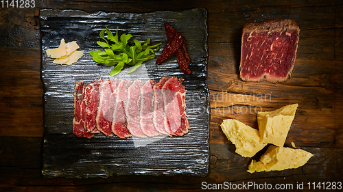 Image of Barbecue wagyu roast beef sliced as top view on a metal tray with copy space right