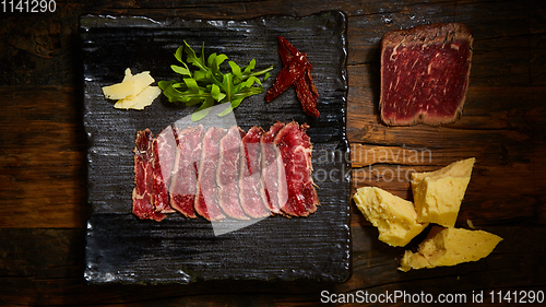 Image of Barbecue wagyu roast beef sliced as top view on a metal tray with copy space right
