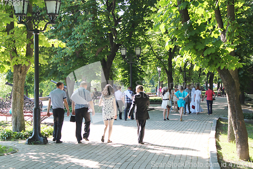 Image of People have a rest in park with greater trees