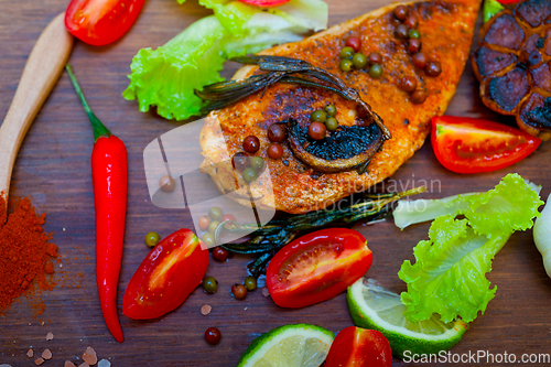 Image of wood fired hoven cooked chicken breast on wood board