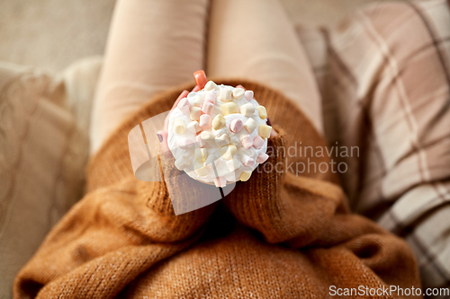 Image of woman holding mug of marshmallow and whipped cream
