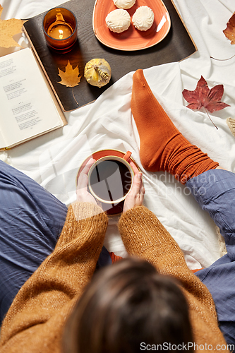 Image of woman drinking coffee at home in autumn