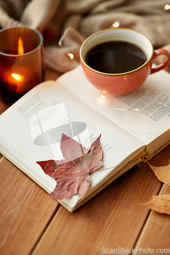 Image of cup of coffee, book on window sill in autumn